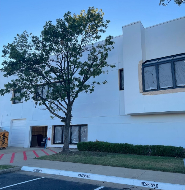 Modern white commercial building with tree landscaping